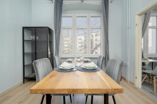 comedor con mesa de madera y sillas en Spacious 3-Bedroom Apartment Plac Grunwaldzki Wrocław by Renters, en Wroclaw