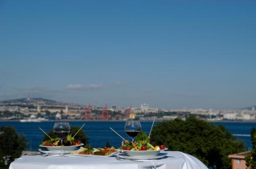 イスタンブールにあるアパート ホテル ヒッポドロームのテーブル(2皿の食べ物とワイングラス付)
