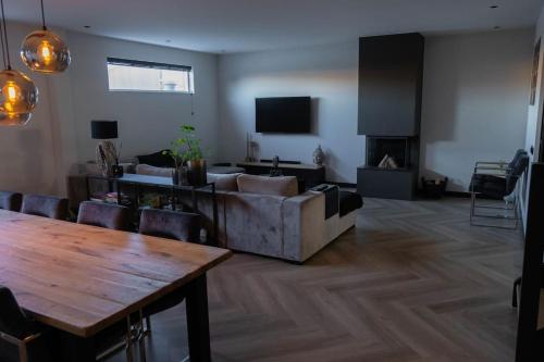 uma sala de estar com um sofá e uma mesa em Luxury home Egmond em Egmond aan Zee
