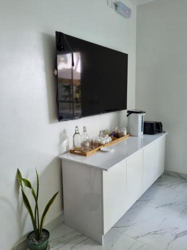 a kitchen with white cabinets and a flat screen tv at Empyrean Stay, Maldives in Thulusdhoo