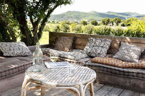 une terrasse avec un canapé et une table avec des verres à vin dans l'établissement LA DEMOISELLE, à Puy-Saint-Martin
