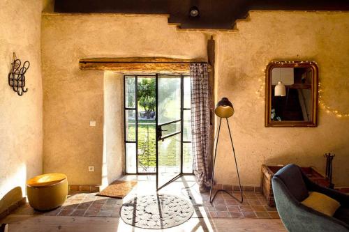 - un salon avec une porte s'ouvrant sur une terrasse dans l'établissement LA DEMOISELLE, à Puy-Saint-Martin