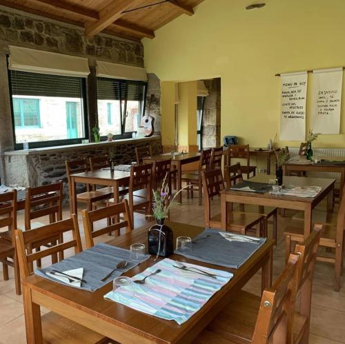 une salle à manger avec des tables et des chaises en bois dans l'établissement Casa Bolboreta, à Palas de Rei