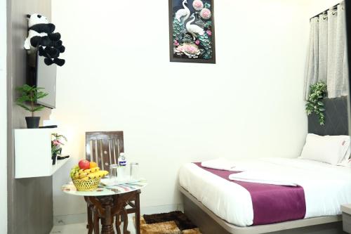 a bedroom with a bed and a table with fruit on it at Hotel River Park in Navi Mumbai