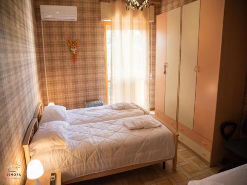 una camera con un letto in una stanza con una finestra di dimora del sole e del vento a Crispiano