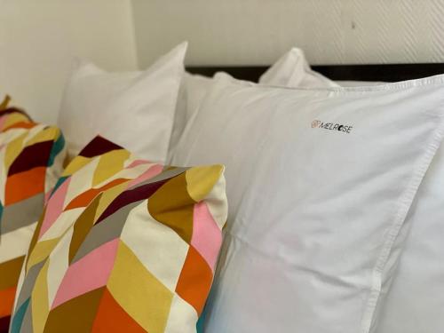 a white shirt and a tie sitting on a bed at Cocon boisé x Parking by Melrose in Bayeux