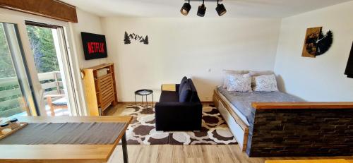 Cozy Studio Retreat - completely renovated in a perfect location في كرانس مونتانا: غرفة معيشة مع أريكة وطاولة