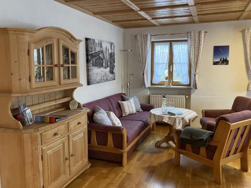 - un salon avec un canapé violet et une table dans l'établissement Ferienhaus Kögel, à Nesselwang