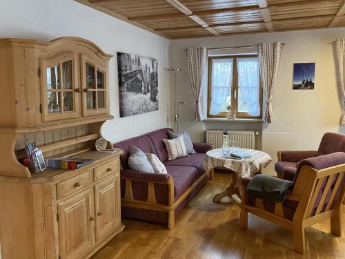 Una sala de estar con un sofá morado y una mesa. en Ferienhaus Kögel, en Nesselwang