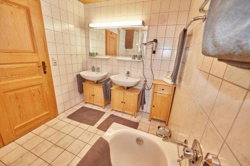 Un baño con dos lavabos y una bañera. en Ferienhaus Kögel, en Nesselwang