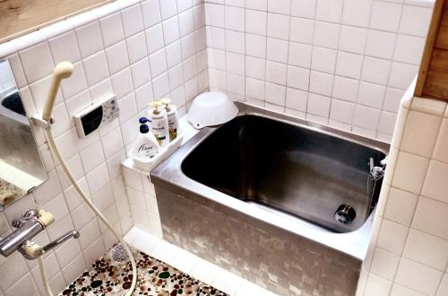 a bath tub in a bathroom with a sink at 箱根小田原 和風一軒貸切 最大7人 テレワーク完備 バス停から徒歩2分 in Odawara