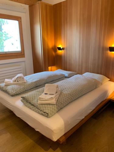 a bedroom with two towels sitting on a bed at Chesa Chavriol in Pontresina