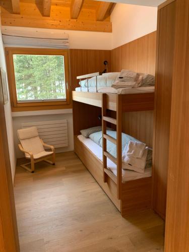 two bunk beds in a small room with a window at Chesa Chavriol in Pontresina
