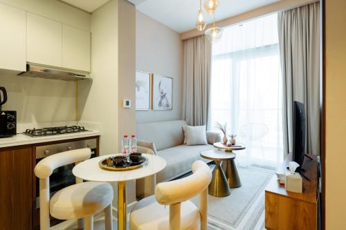- un salon avec un canapé, une table et des chaises dans l'établissement Business Bay - Reva Residence - Keyrock HH, à Dubaï