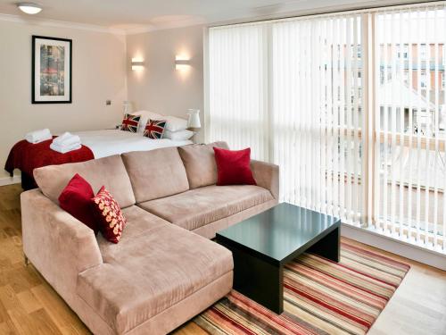 een woonkamer met een bank en een bed bij Your Space Apartments - Byron House in Cambridge