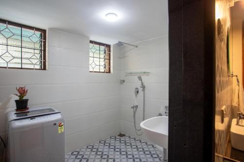 a white bathroom with a sink and a toilet at Whiteboard Homes Siolim in Siolim