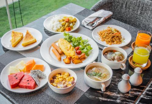 una mesa con platos de comida y tazones de comida en Amethyst Hotel Pattaya, en Pattaya central