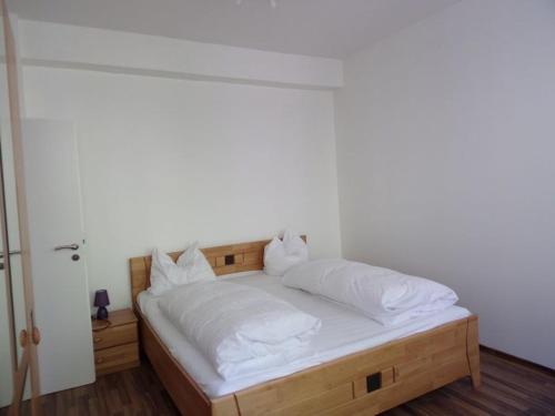 Schlafzimmer mit einem Bett mit weißer Bettwäsche und Kissen in der Unterkunft Linden 4 in Monschau