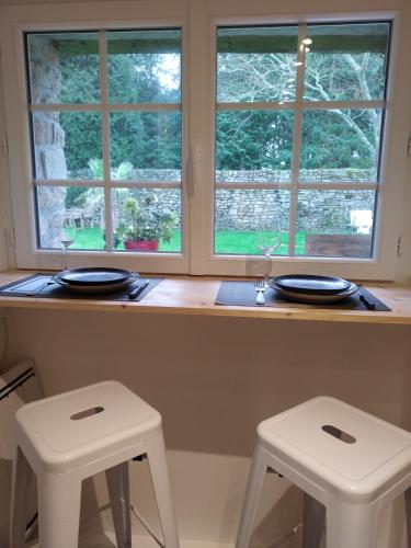 deux tabourets blancs assis à un comptoir avec deux fenêtres dans l'établissement Ty Nid, à Ploemel