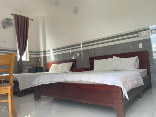 a bedroom with a large bed with a wooden headboard at VIEW HOTEL- TRÀM CHIM in Tràm Chim