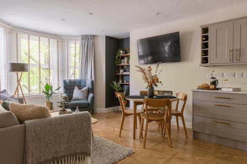 cocina y sala de estar con mesa y sillas en Cohost Partners | Close to City Centre | One BR!, en Cardiff