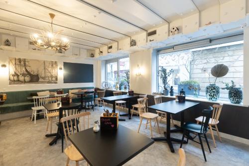 a restaurant with tables and chairs and a large window at Garner Hotel Cologne - Engelbertz by IHG in Cologne