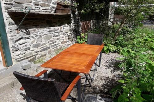 a wooden table and chairs on a patio at Maison Riviére in Monschau
