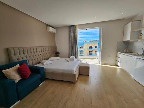 a bedroom with a bed and a blue couch at Dani's Apartments in Sarandë