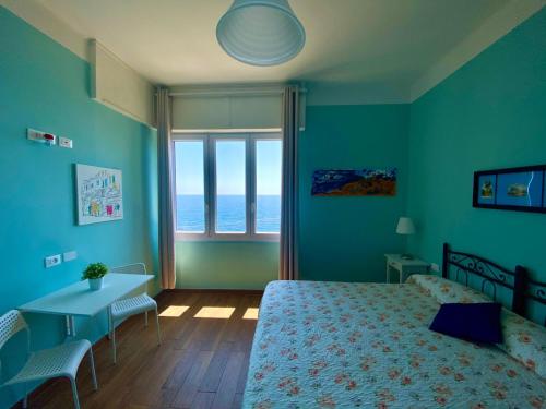 a bedroom with a bed and a table and a window at Casa di Arianna alle Cinque Terre in Corniglia