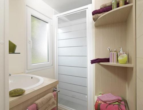 uma casa de banho branca com uma banheira e um lavatório em Camping Las Asperas*** em Palau-de-Cerdagne