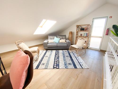 a living room with a couch and a chair at Casa Rostam - Duplex avec Terrasses - Ferragudo in Ferragudo