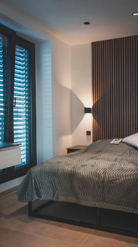 um quarto com uma cama com um candeeiro e 2 janelas em K&T Estate Resort & Spa - Flughafennahe Gästesuite em Hofheim am Taunus