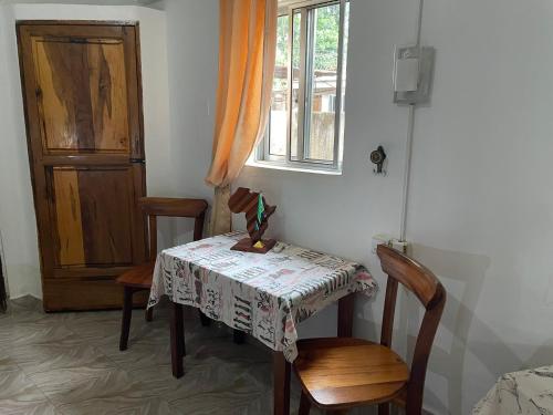 a table and two chairs with a table and a window at Home Feeling Neneu Lodge in Moshi