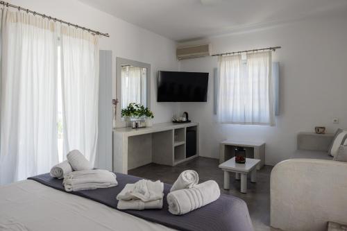 a white room with a bed and a tv at Maryo Village in Naousa