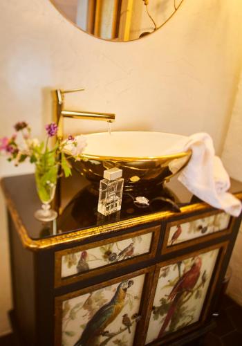 une salle de bain avec un lavabo et un vase de fleurs dans l'établissement Le Mas de la Prade, à Bages