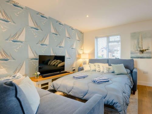 a bedroom with a bed and a tv with sails on the wall at 1 Bed in Hythe 89968 in Hythe