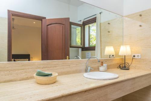 um balcão de casa de banho com um lavatório e um espelho em Ca Na Matas em Son Serra de Marina