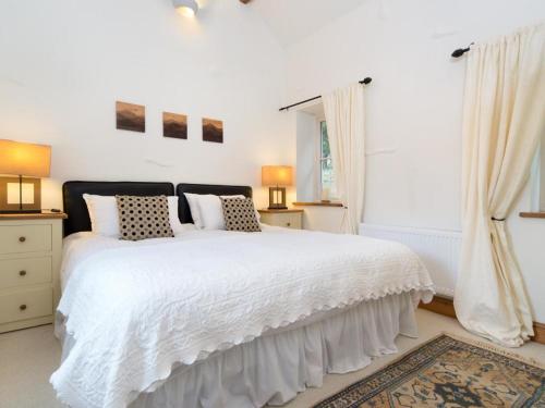 a white bedroom with a large white bed with pillows at 1 Bed in Borrowdale SZ163 in Keswick