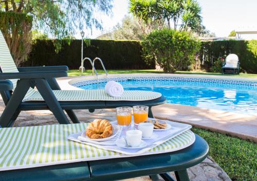 una mesa de picnic con una bandeja de comida junto a una piscina en Casa Segaria, en Denia