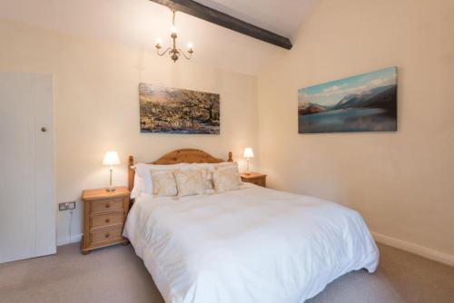 a bedroom with a large white bed and two lamps at 2 Bed in Eskdale SZ346 in Santon Bridge