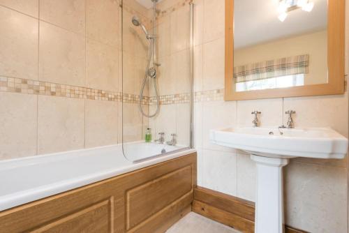 een badkamer met een wastafel, een douche en een bad bij 2 Bed in Eskdale SZ346 in Santon Bridge