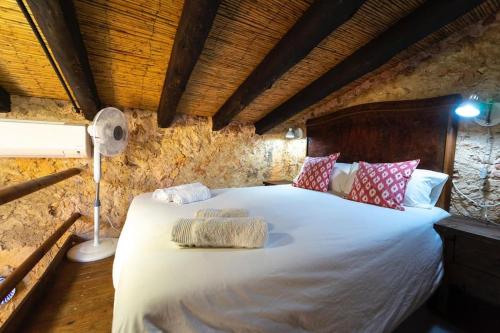 una camera da letto con un grande letto bianco con cuscini di Rustic studio with private pool and private garden a Biniali