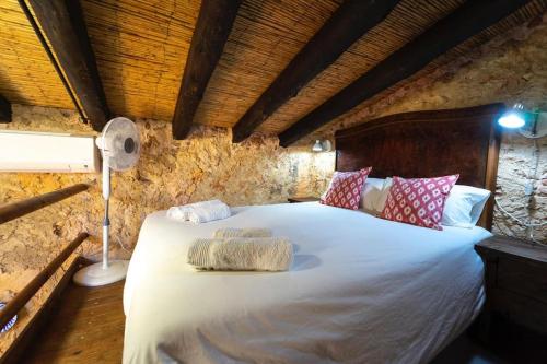 a bedroom with a large white bed with pillows at Can Grau in Biniali