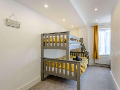 a bedroom with a bunk bed and yellow curtains at 2 Bed in Lyndhurst 86768 in Lyndhurst