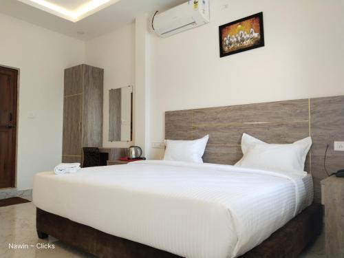 a bedroom with a large bed with white sheets at RedFox Hotel-T.Nagar in Chennai