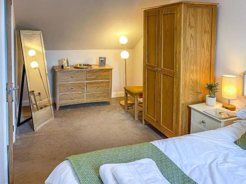 a bedroom with a bed and a dresser and a mirror at 2 Bed in Torquay 82540 in Torquay