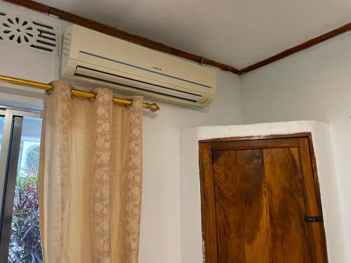 a room with a ceiling fan and a door at Home Feeling Neneu Lodge in Moshi