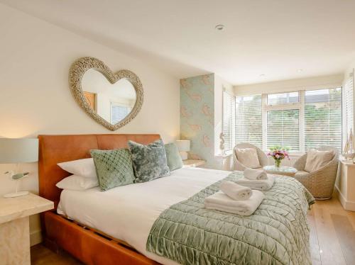 a bedroom with a large bed with a heart mirror on the wall at 1 Bed in Hythe 89966 in Hythe