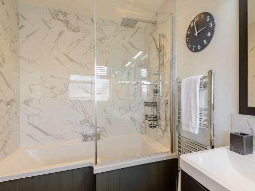 a bathroom with a shower and a clock on the wall at 1 Bed in Hythe 89969 in Hythe