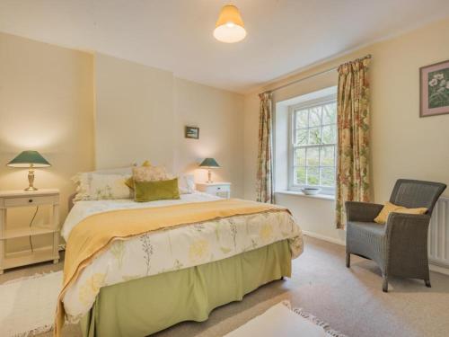 um quarto com uma cama, uma cadeira e uma janela em 4 Bed in Patterdale SZ170 em Patterdale